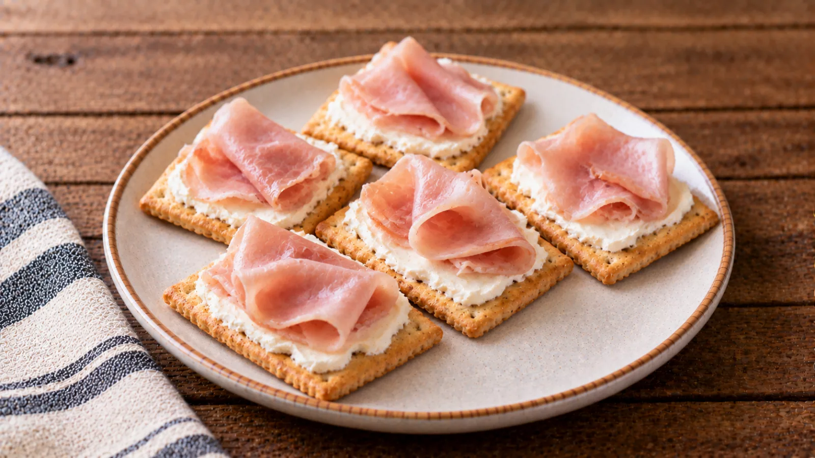 Crackers con formaggio spalmabile e prosciutto cotto